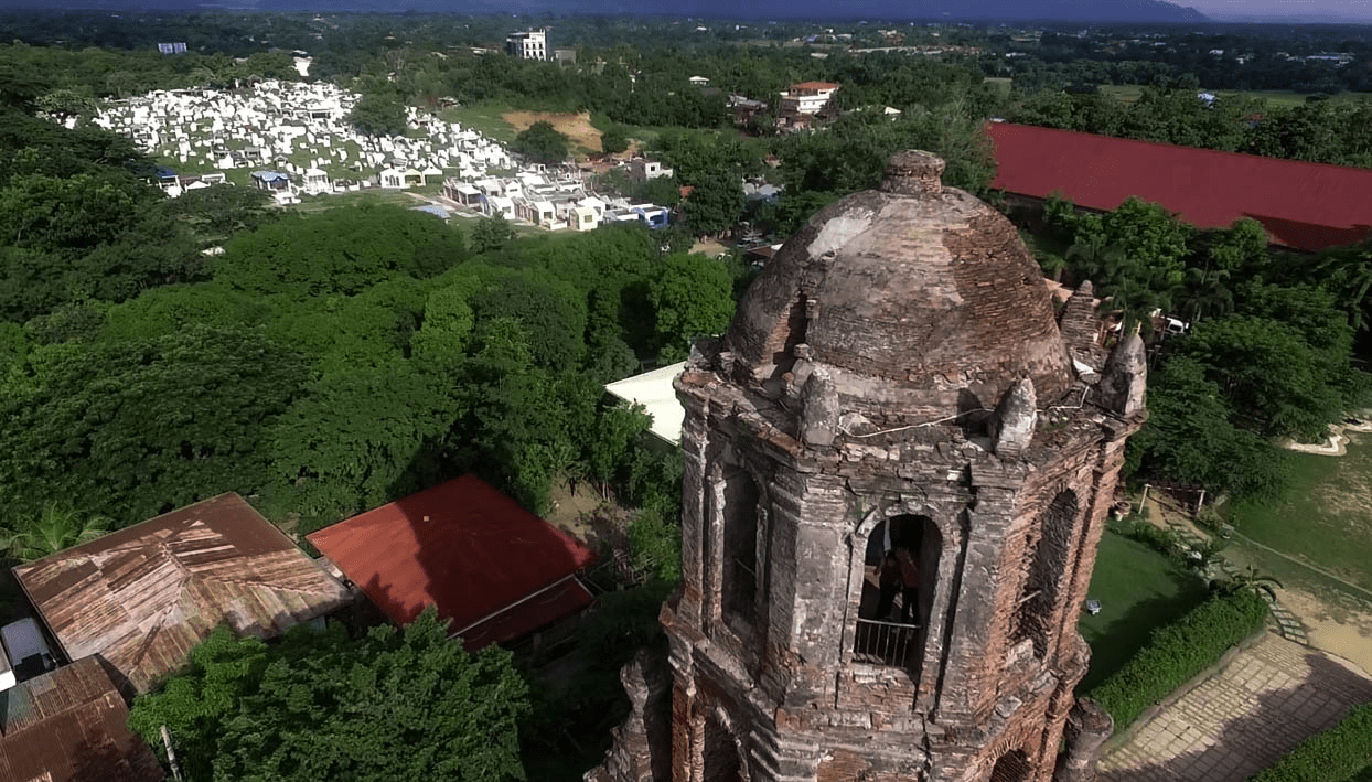 bantay belfry watchtower in vigan city ilocos sur philippines by drone with graveyard on background
